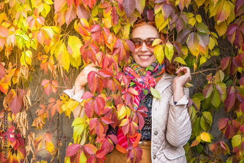 55 year old woman in autumn park with colored leaves