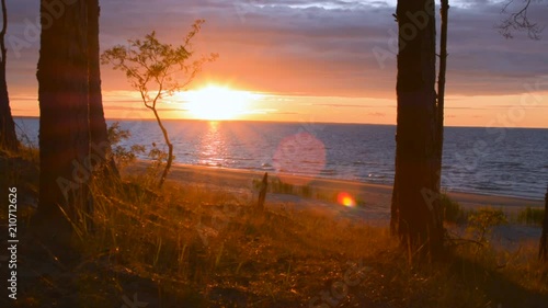 Sunset sunrise with perfect lens flare at dusk dawn on ocean sea shore photo