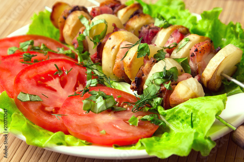 chicken kebab with bacon potatoes, herbs and tomatoes