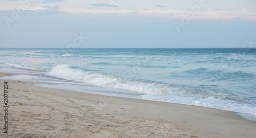 фотографія The waves crashing ashore on the beach at dusk on the east coast.
