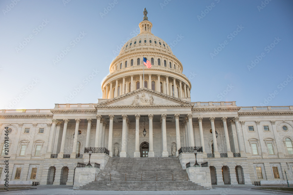 Wide view of the front of the US Capitol Building in Washington, DC without any people and a bright blue sky.