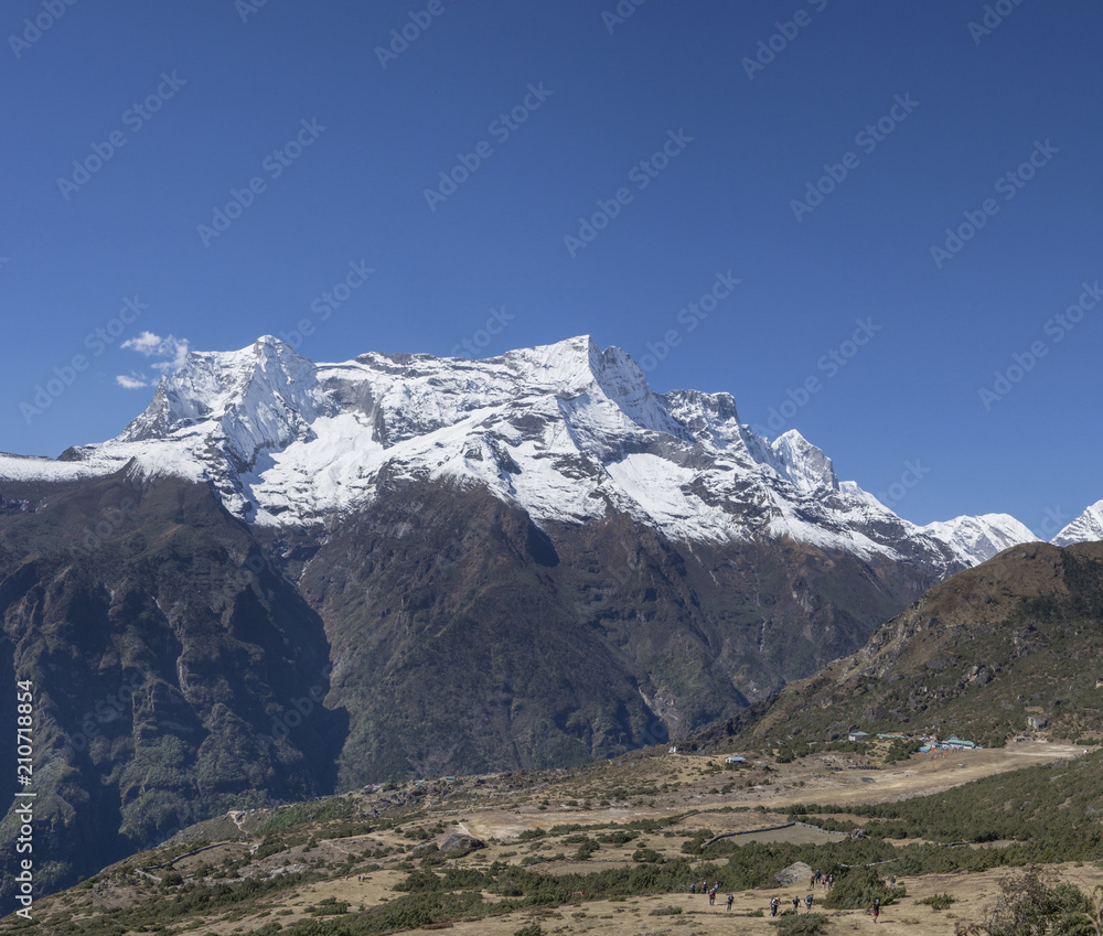 Group of trekkers on a hill and Himalaya summits near Namche Bazaar