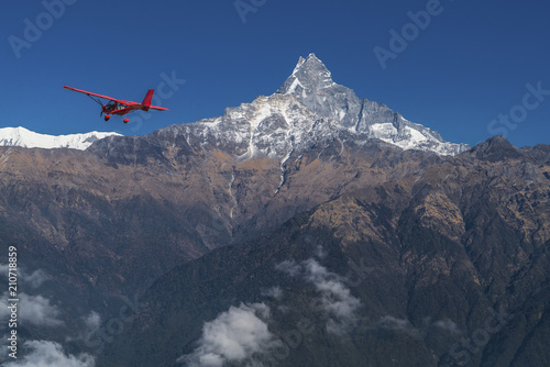 Ultralight plane flies over Pokhara and Machapuchare