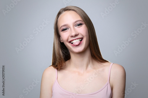 Portrait of young woman on grey background