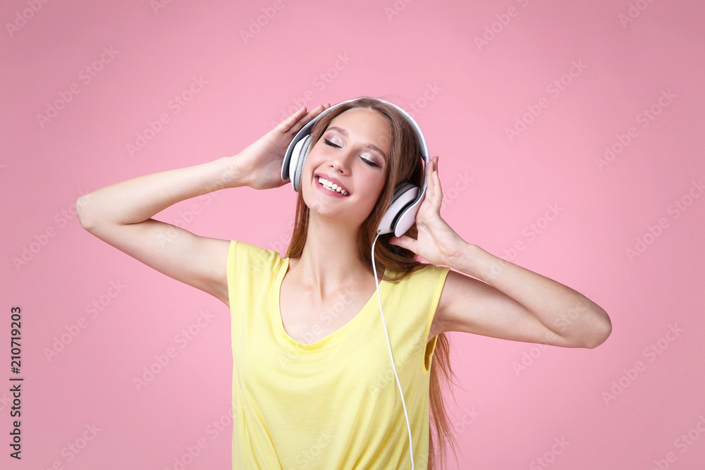 Portrait of young woman with headphones on pink background Portrait of young woman with headphones on pink background