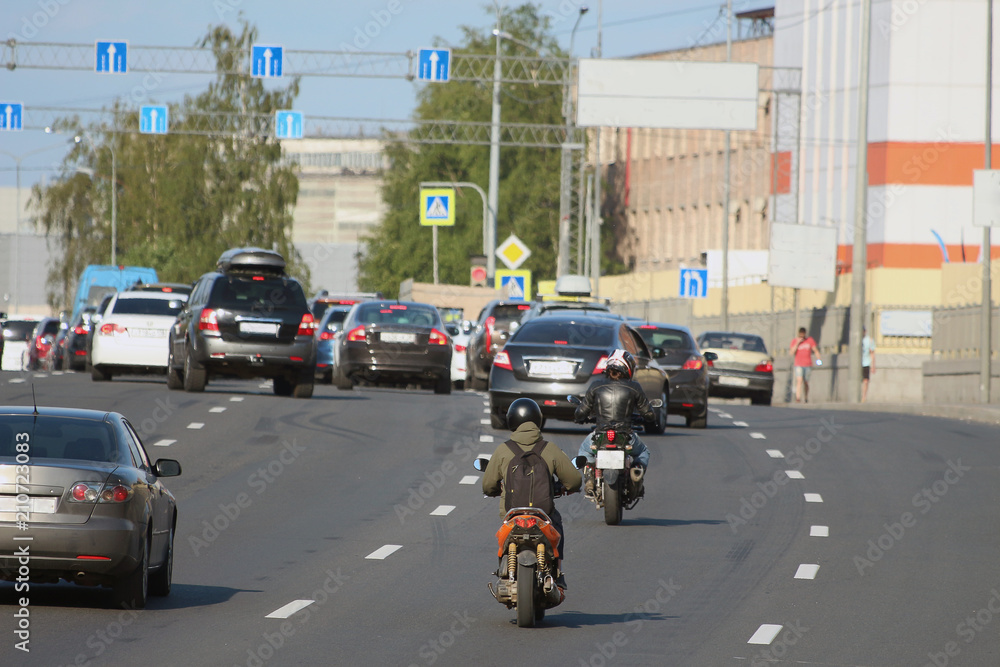 Naklejka premium traffic of cars and motorcycles on a city street