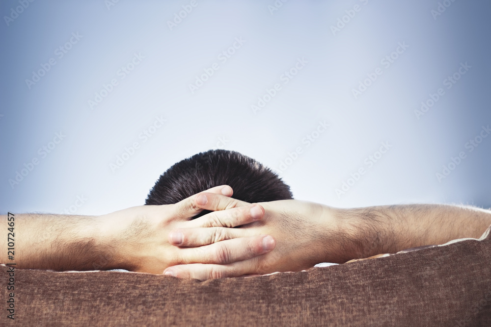 Fototapeta premium Man with hands behind head while watching TV