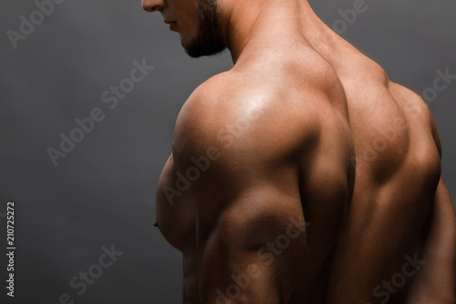 Young handsome muscular man bodybuilder posing in the studio