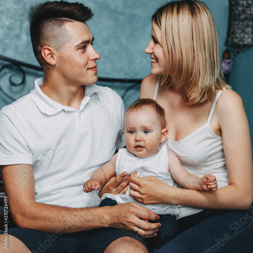 Family time, love, togetherness, parenting concept. Parents and little daughter hugs. Close up of baby girl with her mom and dad enjoy time together