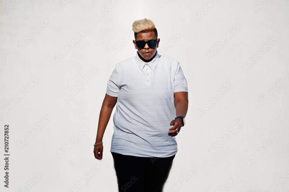 Stylish arabian muslim boy with originally hair and sunglasses posed on streets at roof against white wall. Stylish arabian muslim boy with originally hair and sunglasses posed on streets at roof against white wall.