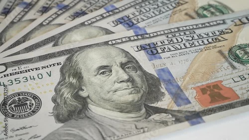 Hundred dollar bills spinning on a table. Close-up. Rotation paper money close-up. Background with money american hundred dollar bills