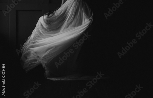 girl whirls in the dark white dress