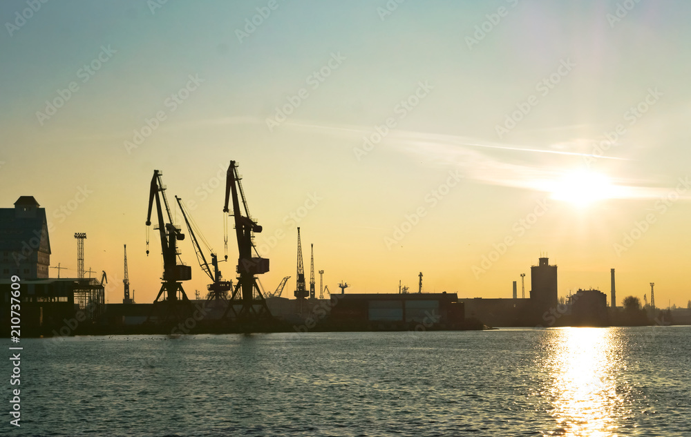 Silhouettes of port cranes at sunset. Kaliningrad commercial fishing port.