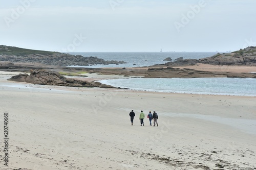 Une famille qui se promène sur la plage de la grève Blanche à Trégastel en Bretagne