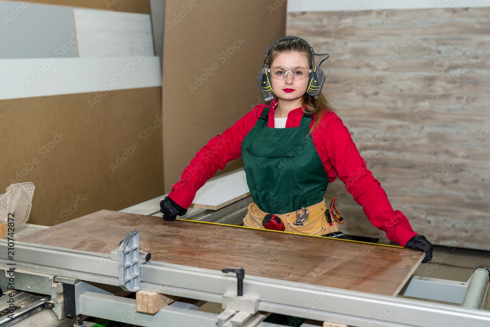 Woman carpenter measure wooden plank in workshop Woman carpenter measure wooden plank in workshop