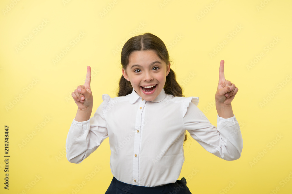 Little genius has an idea. Happy girl keep fingers raised on yellow background. Back to school. Little child smile with inspiration. Great idea. Just inspired. Carefree beauty Little genius has an idea. Happy girl keep fingers raised on yellow background. Back to school. Little child smile with inspiration. Great idea. Just inspired. Carefree beauty