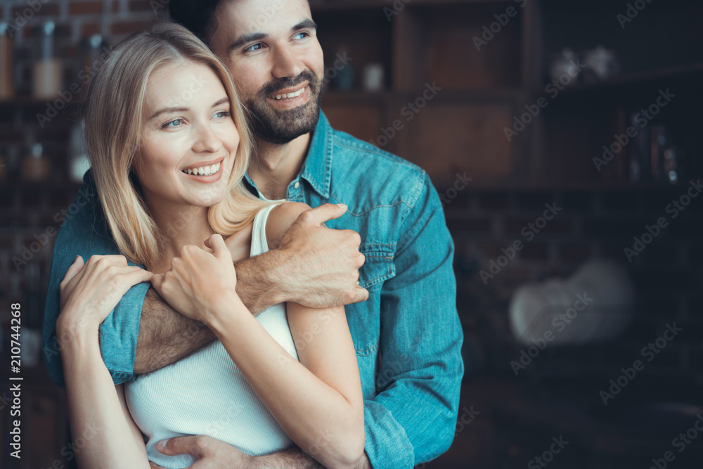 Fototapeta premium Beautiful young couple hugging in their new appartment