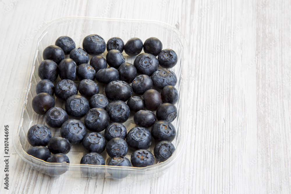 Blueberries in a plastic box, side view. Copy space. Blueberries in a plastic box, side view. Copy space.