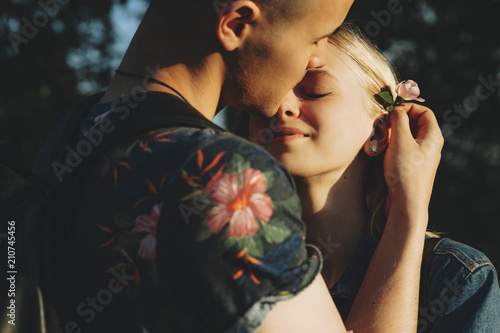 Fotografija Beautiful couple with flower standing at sunset