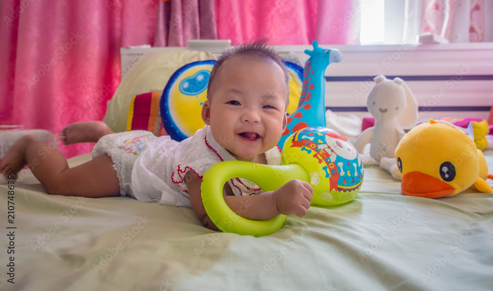 infant baby playing toys on the bed and smiling infant baby playing toys on the bed and smiling