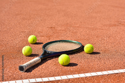 Close up view of tennis racket and balls on the clay tennis court © nikolaborovic88