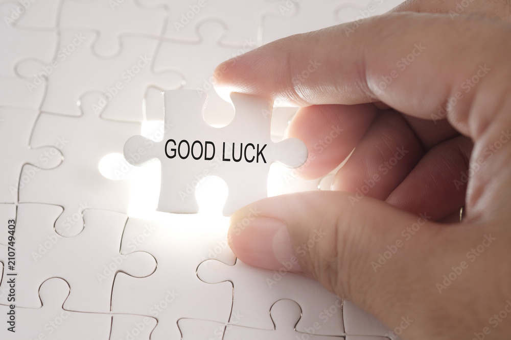 Good luck word on jigsaw puzzle. Businessman hands holding white puzzle business concept. Good luck word on jigsaw puzzle. Businessman hands holding white puzzle business concept.