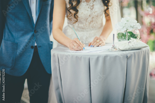 bride and groom sign documents