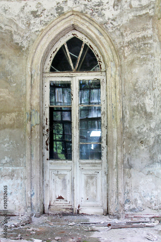 An ancient antique door in the ruins of an abandoned castle.