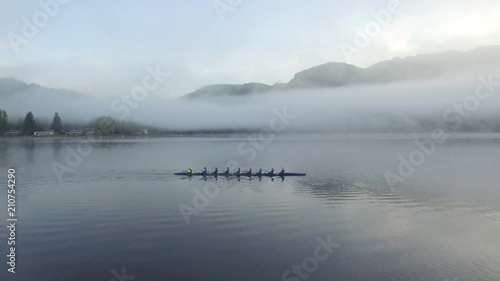 Aerial, clouds over rowers on lake