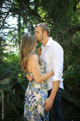 Romantic Couple Side view portrait of a Young Caucasian Couple in an Embrace with Natural Lighting Outside on a Spring or Summer Day © holly