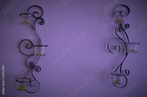 Obraz na plátne Decoraçao de parede feita de ferro com copos de vidro e velas.