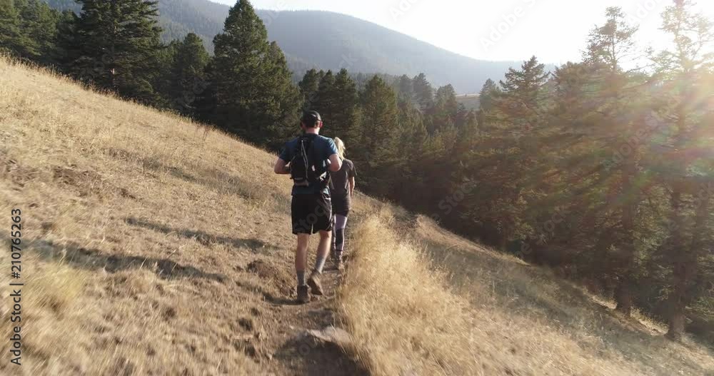 Couple hikes on mountain trail in Montana, aerial Couple hikes on mountain trail in Montana, aerial