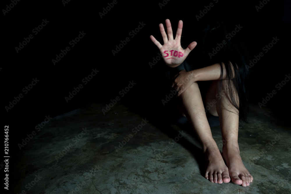 The palm of a female hand giving the signal to stop. The dark, moody image is a concept of a woman being abused, raped, beaten, threatened, robbed, domestic violence etc. The palm of a female hand giving the signal to stop. The dark, moody image is a concept of a woman being abused, raped, beaten, threatened, robbed, domestic violence etc.