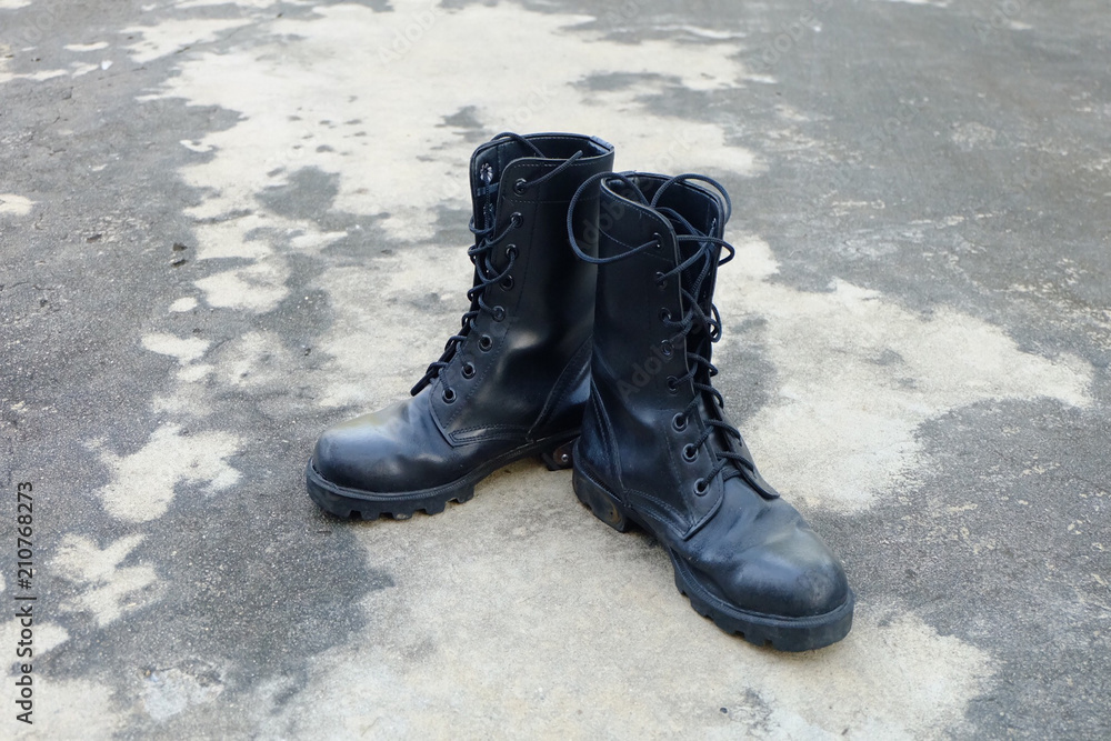 Man Boot Black Military Shoes Isolated. Top View. Black Combat Boots on Gray Concrete Background Man Boot Black Military Shoes Isolated. Top View. Black Combat Boots on Gray Concrete Background