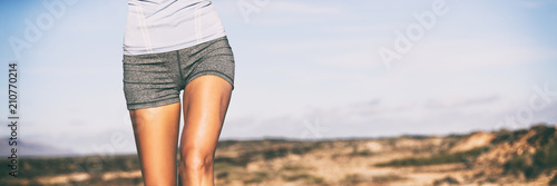 Exercise weigth loss fitness concept runner woman running on trail closeup of hips and legs. Sportswear girl wearing shorts outdoors banner panorama. photo