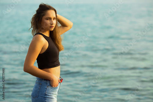Beautiful young woman near sea posing for a camera