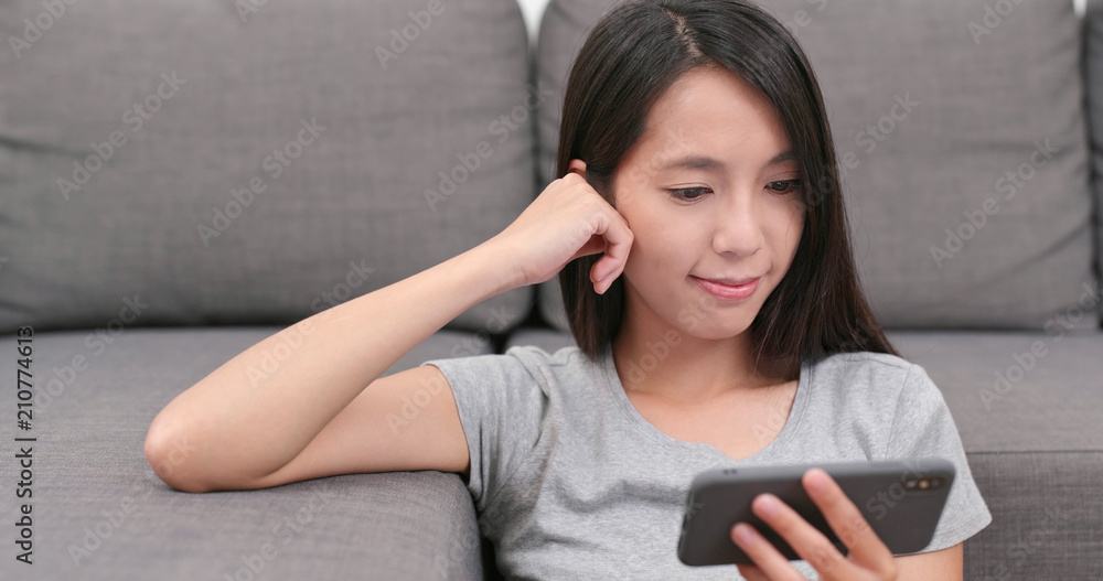 Woman watch on cellphone at homeWoman watch on cellphone at home Woman watch on cellphone at homeWoman watch on cellphone at home