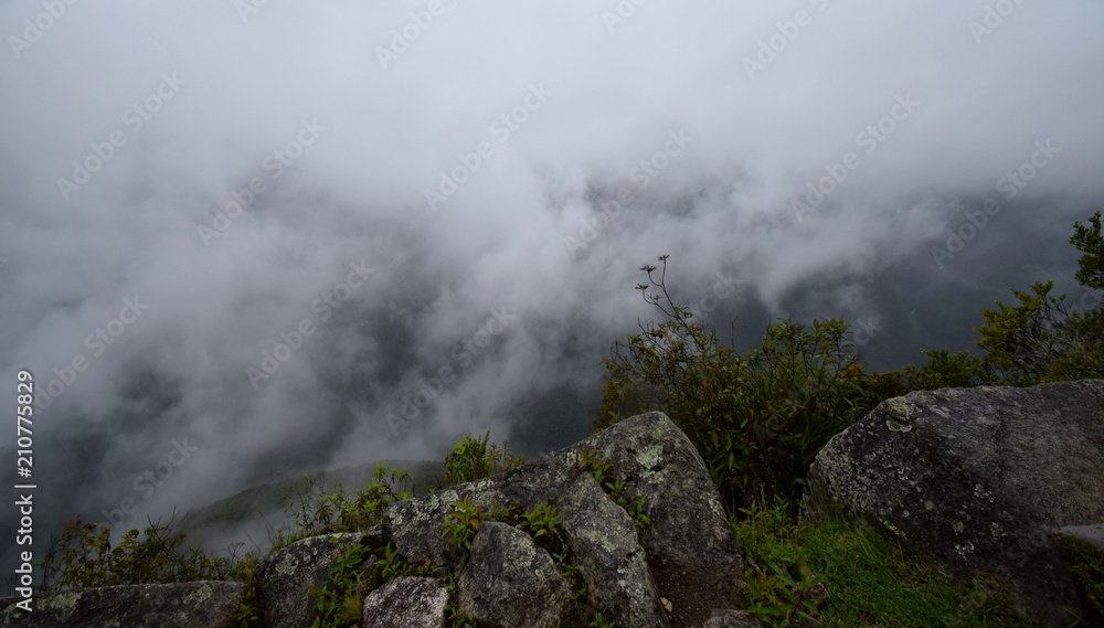 a shot of the clouds from over them after hiking on top of a mountain