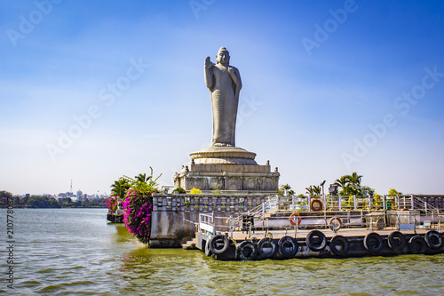 Sailing by the Giant Buddha Statue with Bright Pink Bougainvillea Plants in the Middle of Hussain Sagar Lake in Hyderabad, India photo