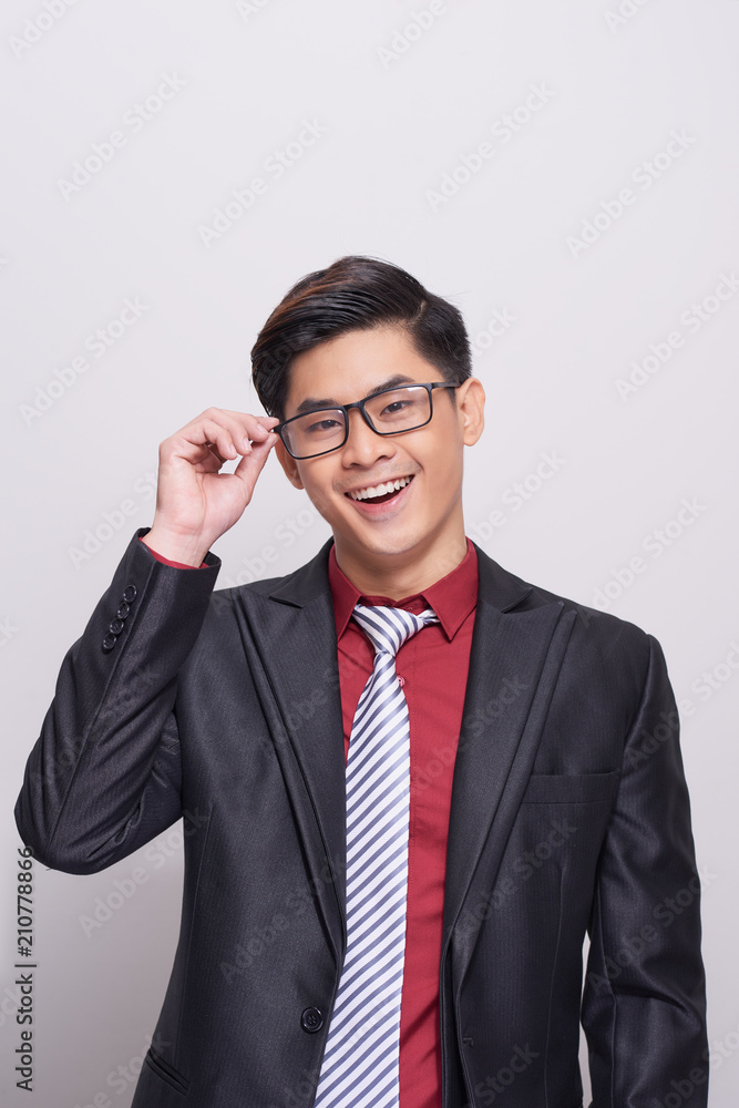 Handsome and well dressed businessman in a suit, tie and vest, standing against a white background smiling towards camera. Handsome and well dressed businessman in a suit, tie and vest, standing against a white background smiling towards camera.