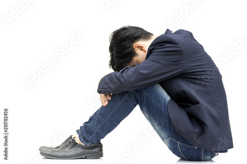 Tableau sur toile Young businessman sitting knee bent his head to his arms isolate on white