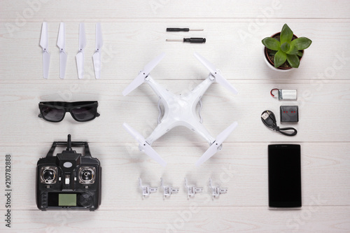 Drone set and spare parts. Flat lay composition on white wooden background. photo