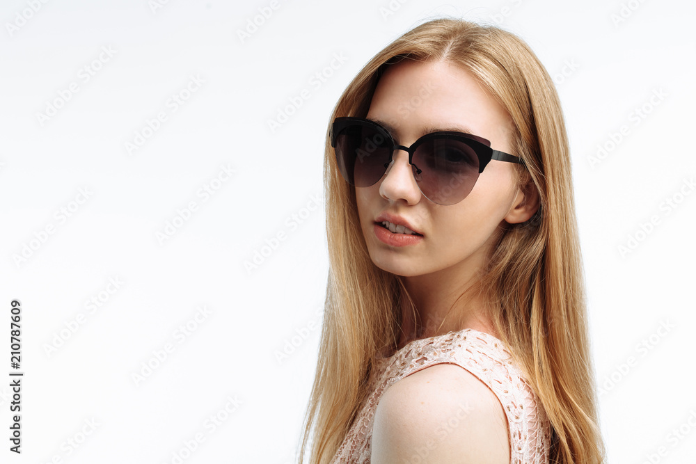 Portrait of a young stylish girl, model posing with glasses on a white background, for advertising Portrait of a young stylish girl, model posing with glasses on a white background, for advertising