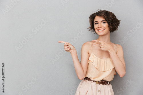 Portrait of a smiling young woman pointing fingers away