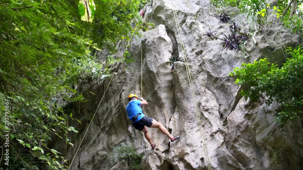 The climber descends on the safety rope The climber descends on the safety rope