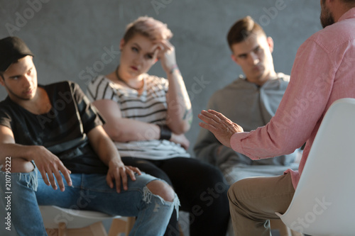 Psychotherapist supporting difficult teenagers during group therapy