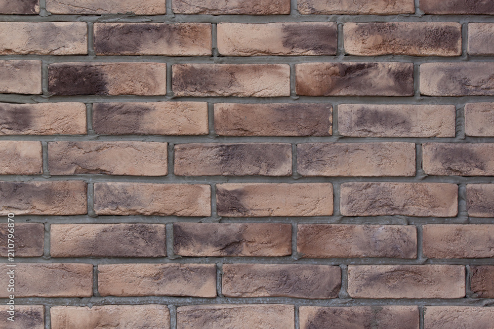 Obraz premium Brick wall with spotted brown bricks. Used as a background.