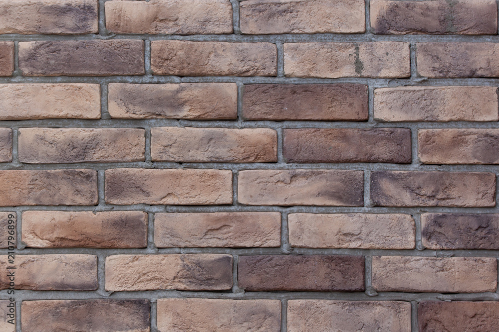 Brick wall with variegated brown bricks. Used as a background. Brick wall with variegated brown bricks. Used as a background.