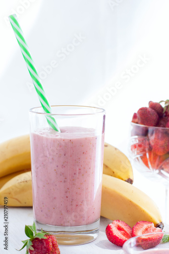 Smoothies of strawberries and bananas in glass glasses on a white table, selective focus