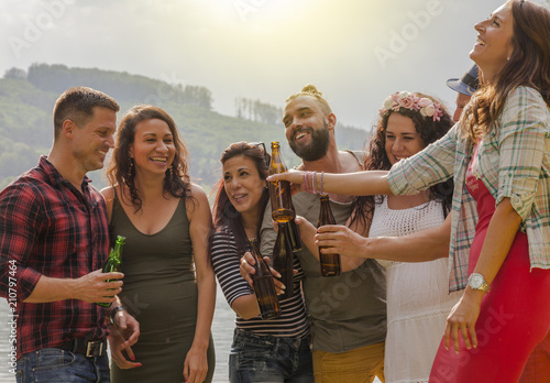 freunde haben spass bei einer ungezwungenen gartenparty. alle trinken bier und sind leicht angetrunken. photo